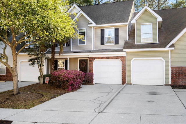 view of property featuring brick siding, concrete driveway, an attached garage, and a shingled roof