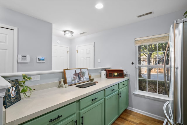 bathroom with vanity, wood finished floors, baseboards, and visible vents