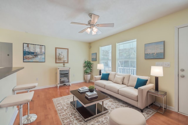 living room with electric panel, ceiling fan, and light hardwood / wood-style floors