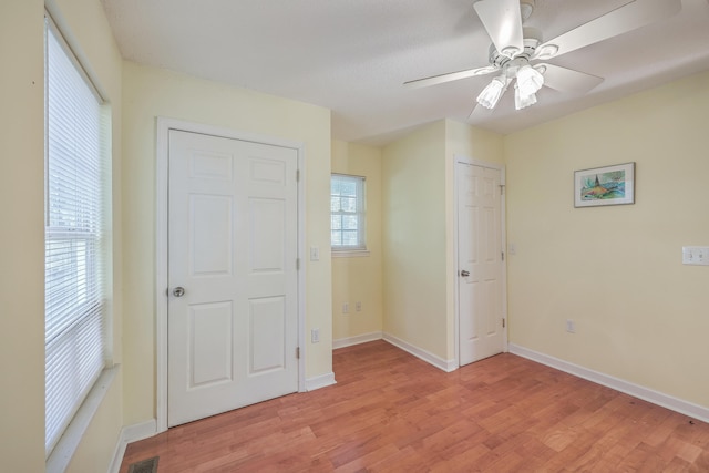 unfurnished bedroom featuring ceiling fan, light hardwood / wood-style flooring, and multiple windows