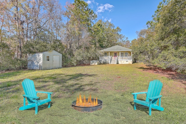 view of yard with a storage unit, covered porch, and an outdoor fire pit