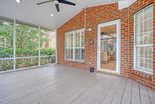 unfurnished sunroom with vaulted ceiling and a ceiling fan