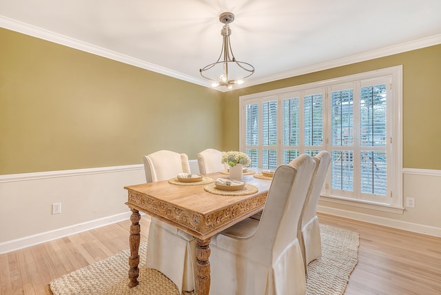 dining space with light wood finished floors, baseboards, a chandelier, and crown molding