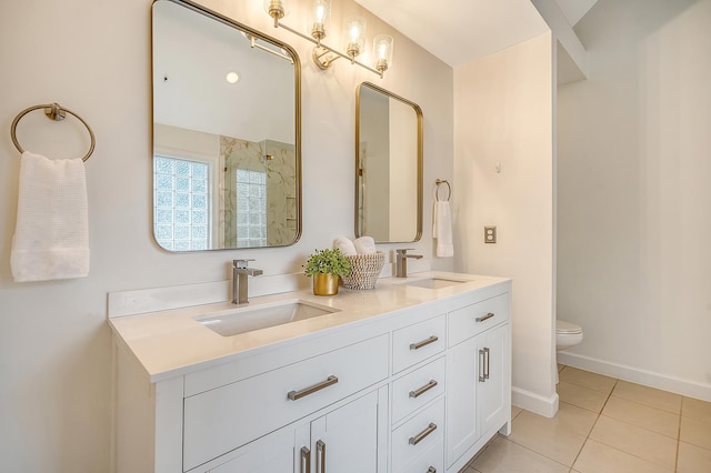 full bathroom with baseboards, double vanity, a sink, and tile patterned floors