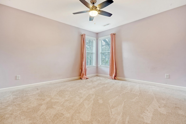 unfurnished room featuring baseboards, ceiling fan, visible vents, and light colored carpet