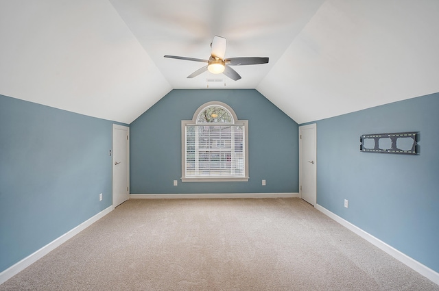 additional living space with carpet, lofted ceiling, visible vents, a ceiling fan, and baseboards