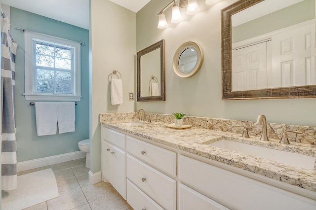 full bathroom featuring double vanity, a sink, toilet, and tile patterned floors