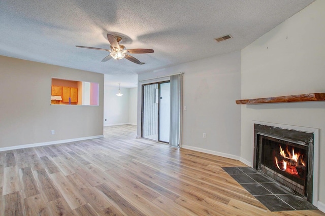 607 Waterwood Dr, Goose Creek, SC 29445 - unfurnished living room featuring a ceiling fan, a textured ceiling, visible vents, a fireplace with flush hearth, and wood finished floors