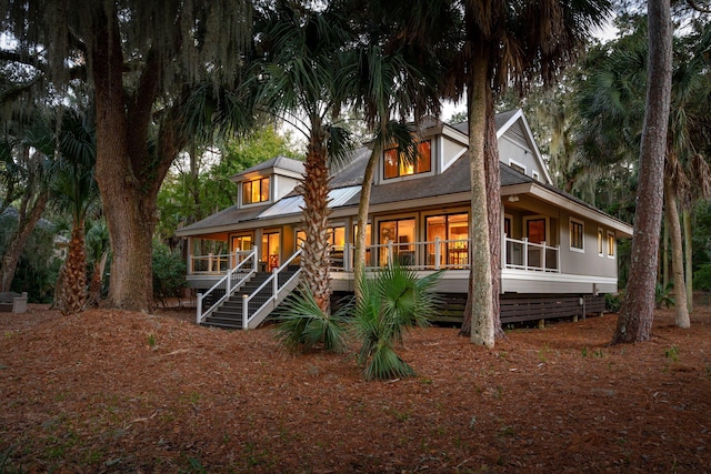 rear view of property featuring covered porch