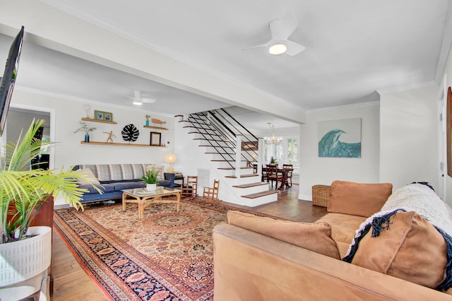 living room featuring crown molding, ceiling fan with notable chandelier, and hardwood / wood-style flooring