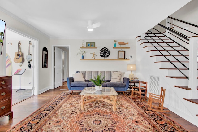 living room with wood-type flooring, ceiling fan, and ornamental molding