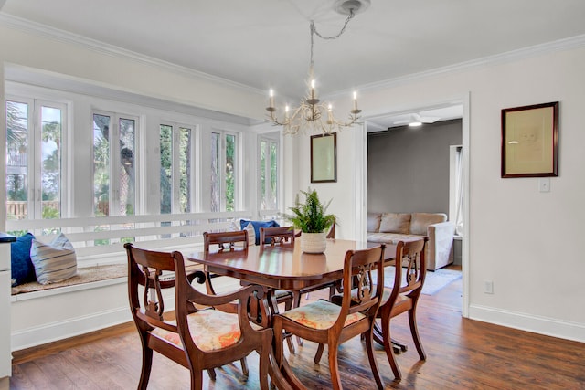 dining space featuring dark wood-type flooring, a chandelier, and crown molding