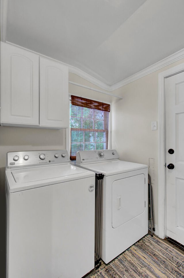 washroom with ornamental molding, independent washer and dryer, and cabinets