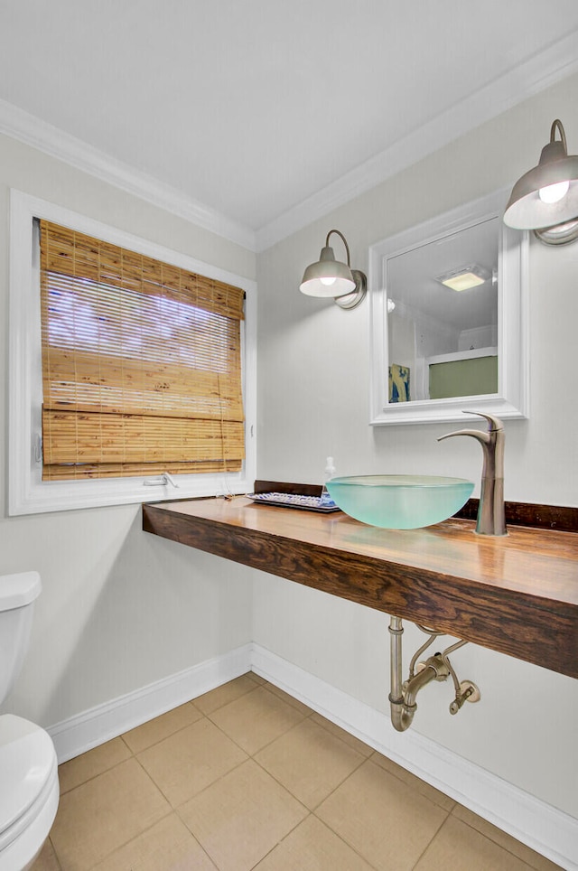 bathroom featuring crown molding, toilet, sink, and tile patterned floors