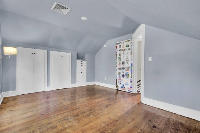 additional living space featuring lofted ceiling and wood-type flooring