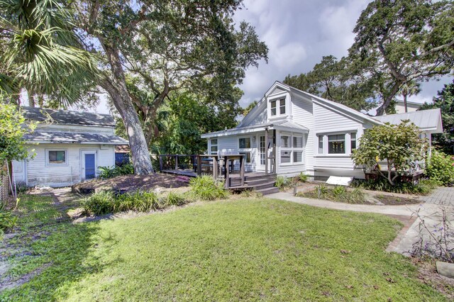 view of front facade featuring a front lawn and a wooden deck