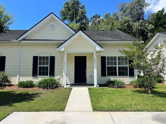bungalow-style home featuring a front lawn, a porch, and roof with shingles