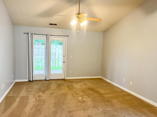 carpeted empty room with a ceiling fan and baseboards