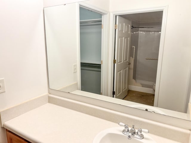 full bathroom featuring a shower, vanity, and toilet