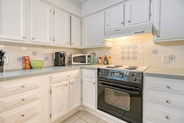 kitchen with black electric range oven, ventilation hood, white cabinets, light tile patterned floors, and white microwave