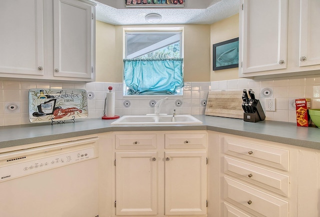 kitchen featuring a sink, decorative backsplash, dishwasher, and white cabinetry