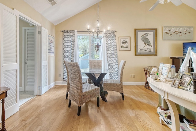 dining space featuring ceiling fan with notable chandelier, baseboards, light wood-type flooring, and lofted ceiling