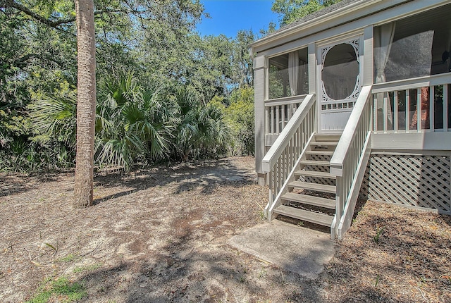 view of yard with stairs and a sunroom