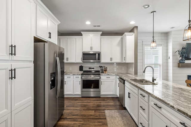 423 Sanctuary Park Dr, Summerville, SC 29486 - kitchen featuring appliances with stainless steel finishes, white cabinetry, dark wood finished floors, decorative light fixtures, and backsplash