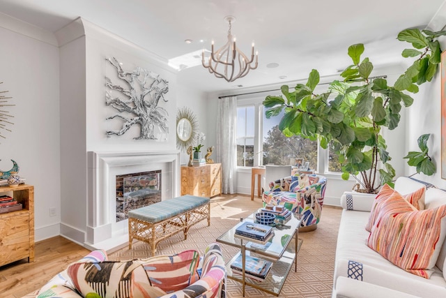 living room featuring a chandelier, light hardwood / wood-style floors, and crown molding