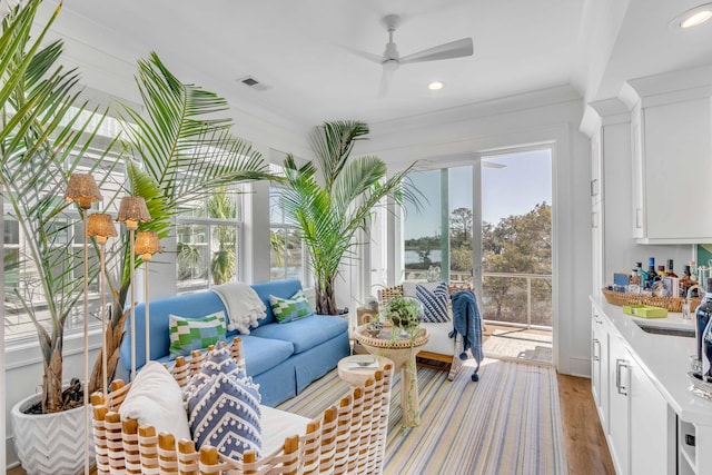 sunroom featuring ceiling fan and sink