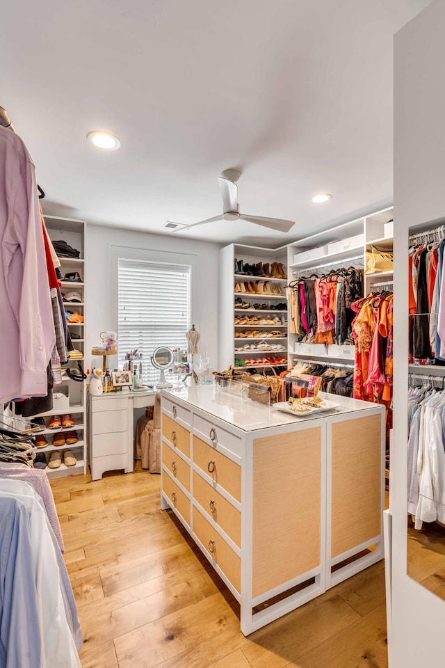 walk in closet featuring light hardwood / wood-style floors and ceiling fan