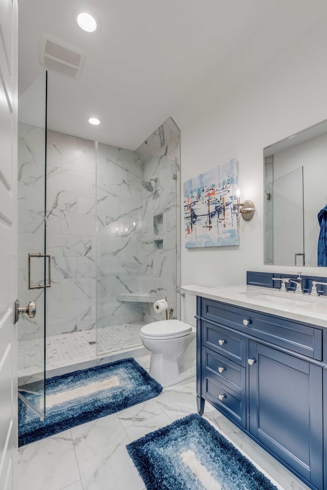 bathroom featuring vanity, a shower with shower door, and toilet