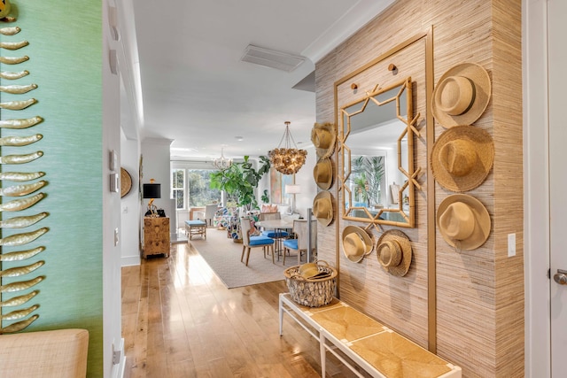 corridor with an inviting chandelier and hardwood / wood-style floors