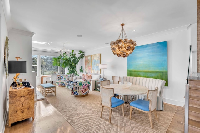 dining space featuring light hardwood / wood-style flooring, a chandelier, and crown molding