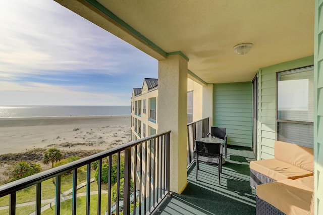 balcony featuring a beach view and a water view