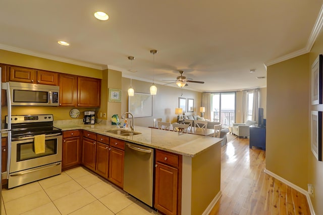 kitchen with crown molding, appliances with stainless steel finishes, kitchen peninsula, and sink