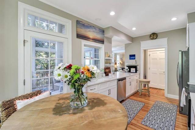 kitchen featuring white cabinetry, appliances with stainless steel finishes, a wealth of natural light, and light wood-type flooring