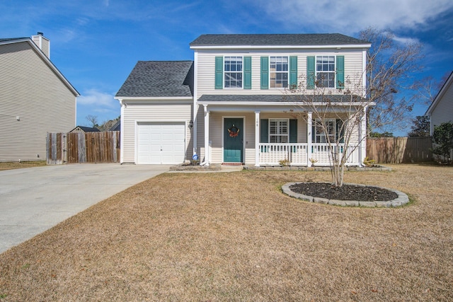 traditional-style house featuring a porch, a garage, fence, driveway, and a front lawn