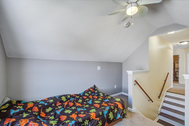 carpeted bedroom with ceiling fan, baseboards, vaulted ceiling, and a textured ceiling