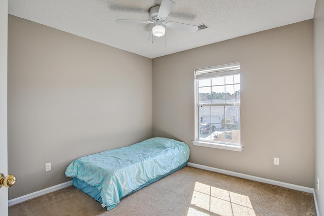 bedroom featuring a textured ceiling, carpet floors, and baseboards