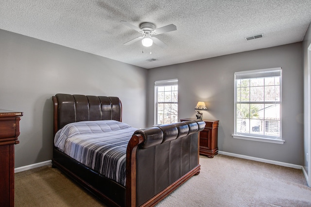 bedroom with baseboards, visible vents, and light colored carpet