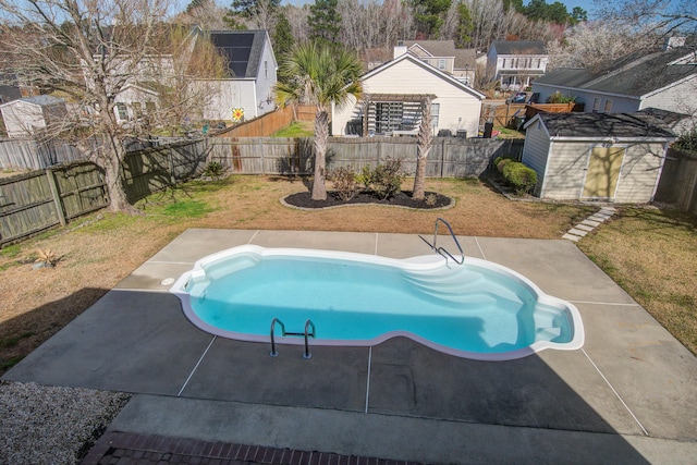 view of swimming pool with an outbuilding, a patio area, and a fenced backyard