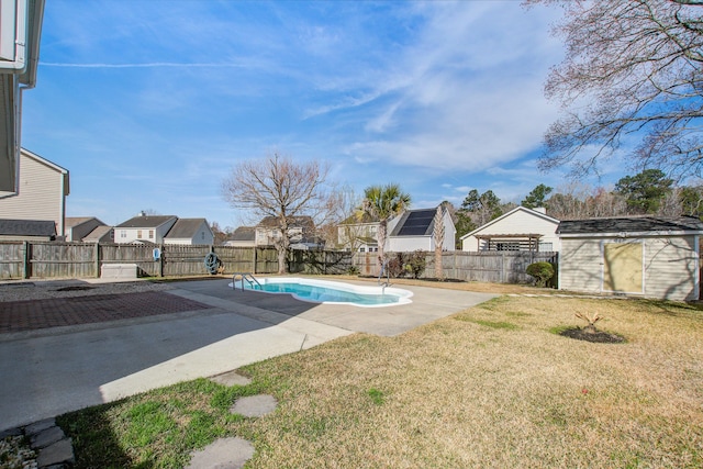 view of pool with a storage shed, a lawn, a patio, a fenced backyard, and an outdoor structure