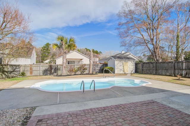 view of swimming pool with an outbuilding, a patio area, and a fenced backyard