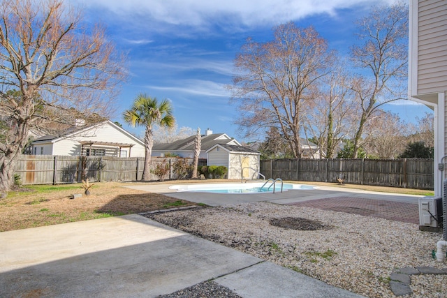 view of pool with an outbuilding, a storage shed, a patio area, and a fenced backyard