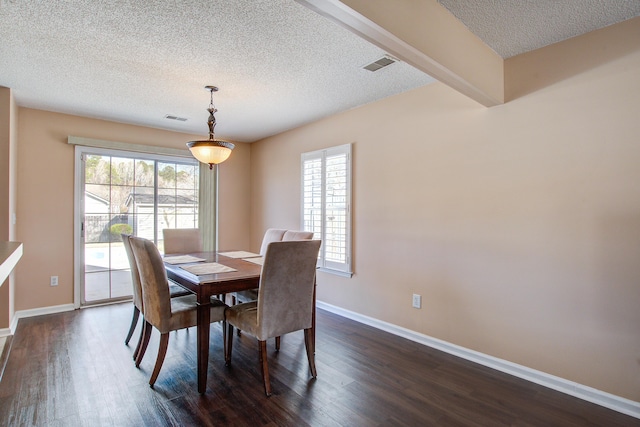 dining space with dark wood-style floors, visible vents, and baseboards