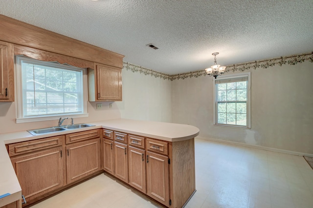 441 Compton Dr, Moncks Corner, SC 29461 - kitchen featuring a sink, a peninsula, a textured ceiling, a chandelier, and light countertops