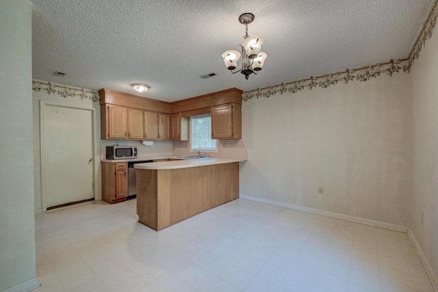 441 Compton Dr, Moncks Corner, SC 29461 - kitchen featuring appliances with stainless steel finishes, a textured ceiling, a chandelier, a peninsula, and light countertops