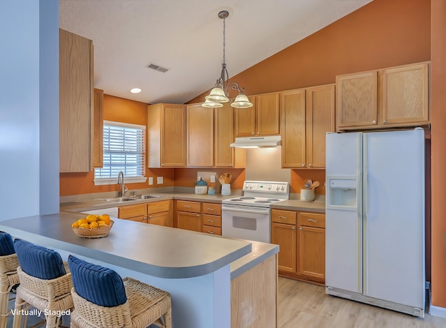 kitchen featuring visible vents, under cabinet range hood, a peninsula, white appliances, and a sink