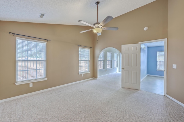 spare room featuring visible vents, light colored carpet, a ceiling fan, and a textured ceiling